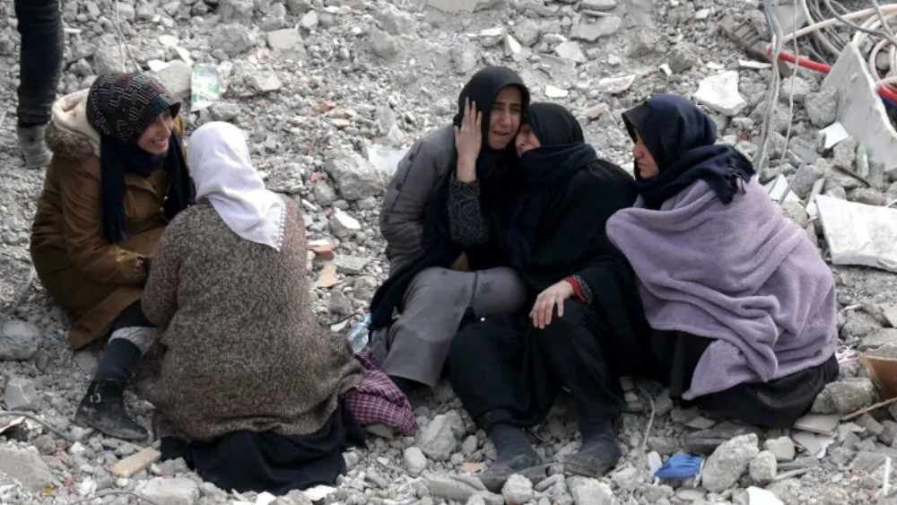 Люди на месте обрушения здания после мощного землетрясения в городе Кахраманмараш, Турция
